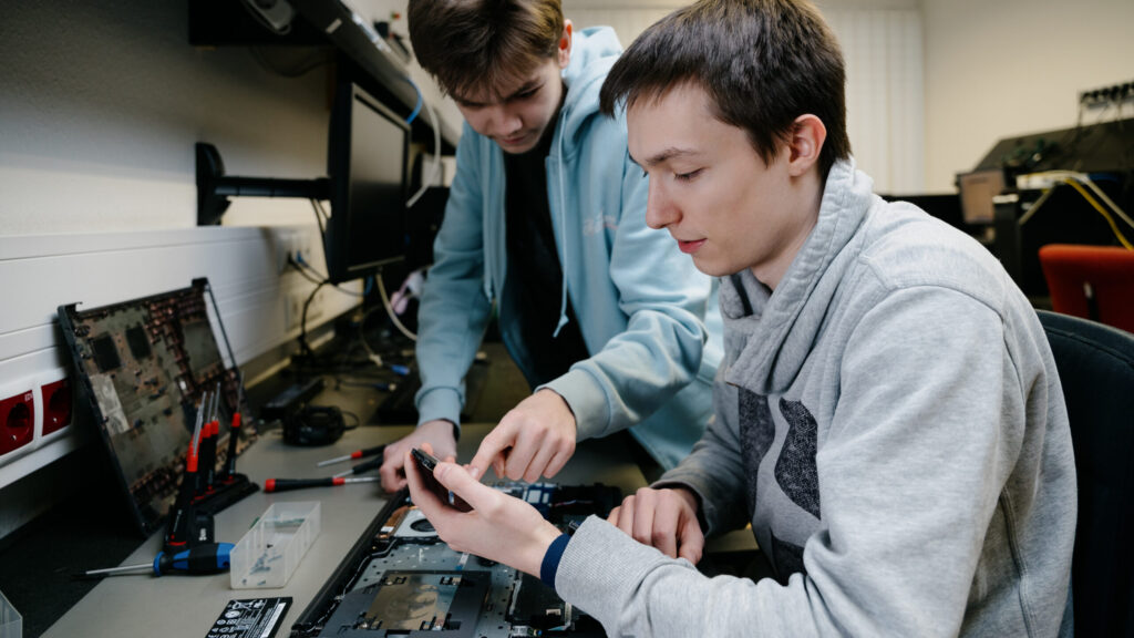 IT Techniker schrauben an einem Notebook